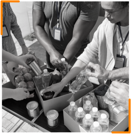 Volunteers assembling food packages, including fresh produce and canned goods, for distribution as part of the hunger relief program.